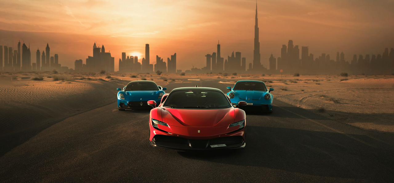 Porsche, Ferrari, and Maserati parked in the desert with Dubai skyline in the background.